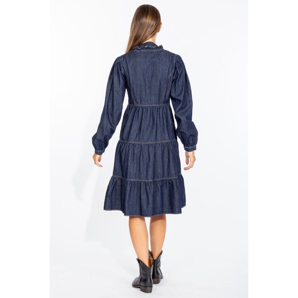 Back view of a woman wearing a Love Moschino denim dress with long sleeves and tiered skirt