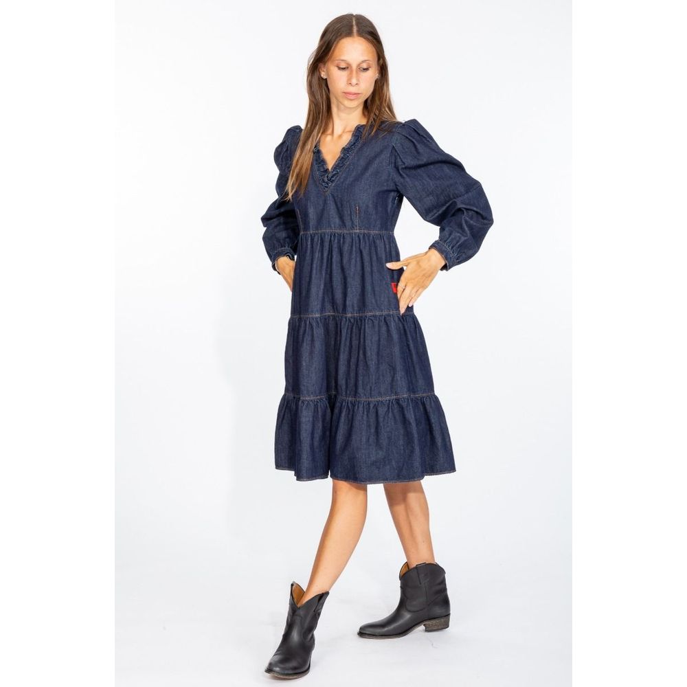 Woman wearing a Love Moschino denim dress with puffed sleeves and tiered skirt in dark blue