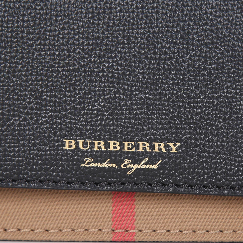 Close-up of Burberry crossbody bag black textured leather with gold logo and signature check pattern