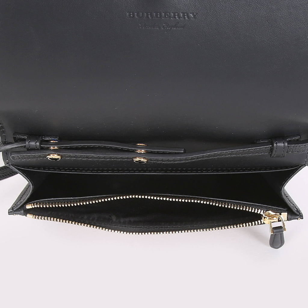 Open black Burberry crossbody bag black showing zippered main compartment with gold-tone zipper