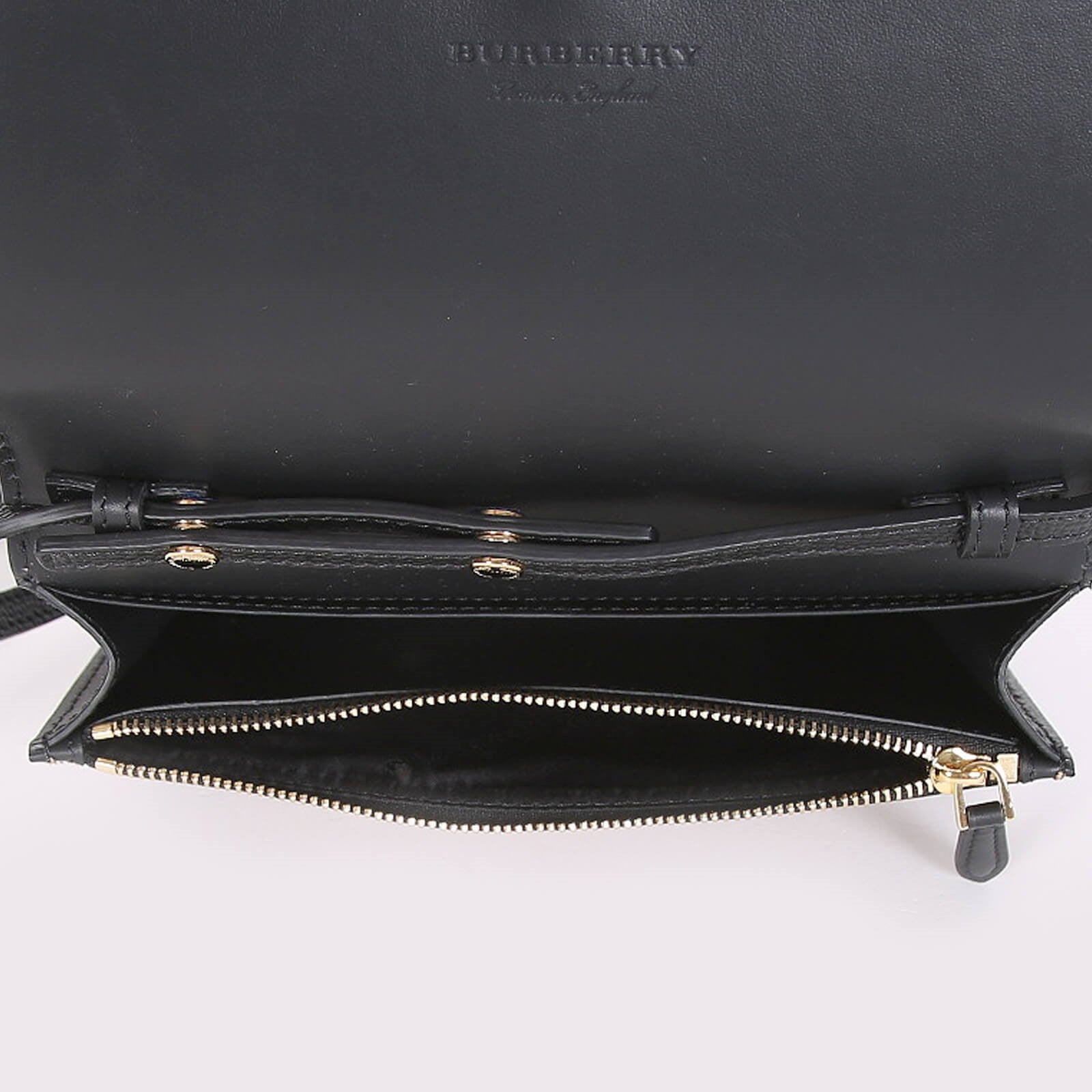 Open black Burberry crossbody bag black showing zippered main compartment with gold-tone zipper
