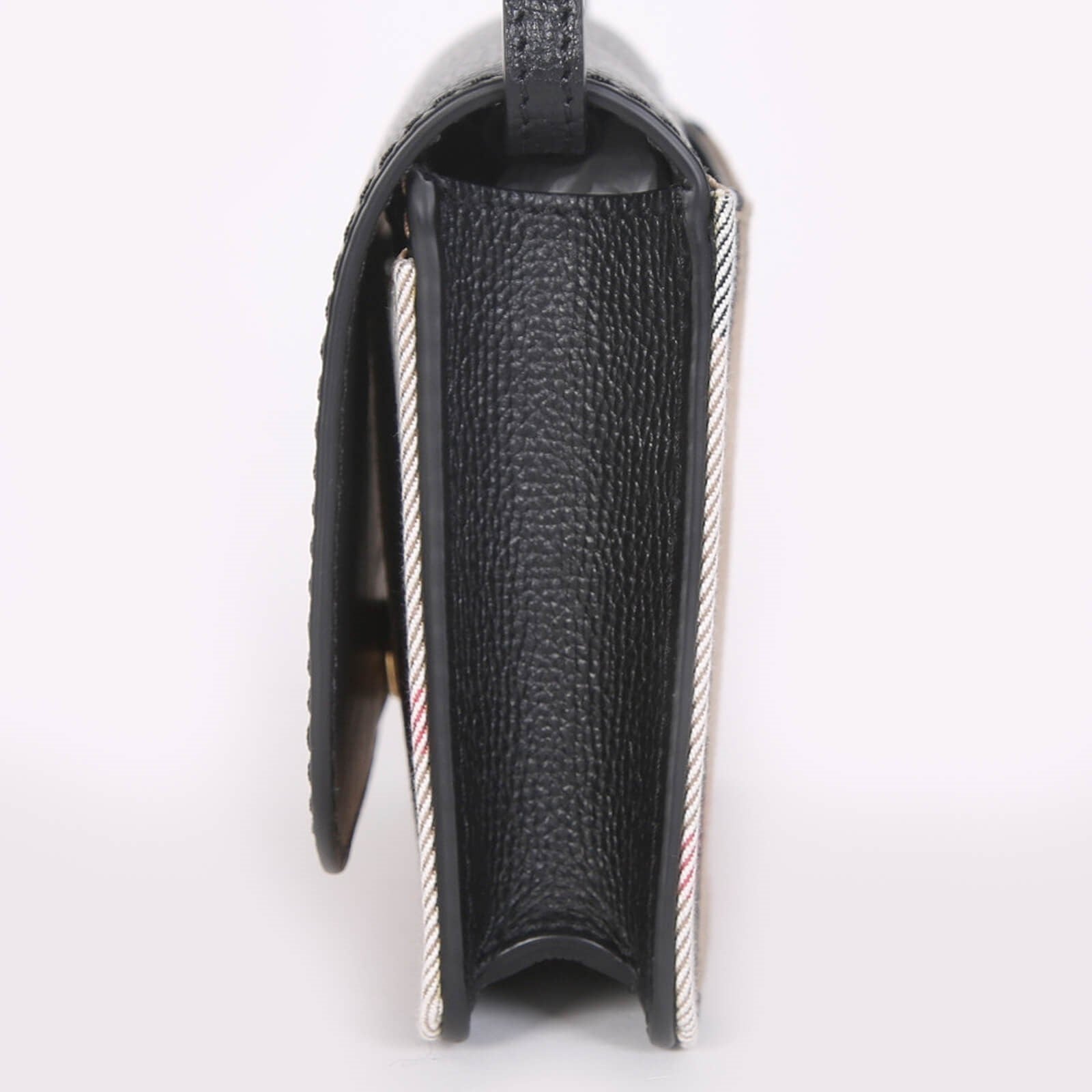 Side view of Burberry crossbody bag black with textured leather and signature check pattern trim