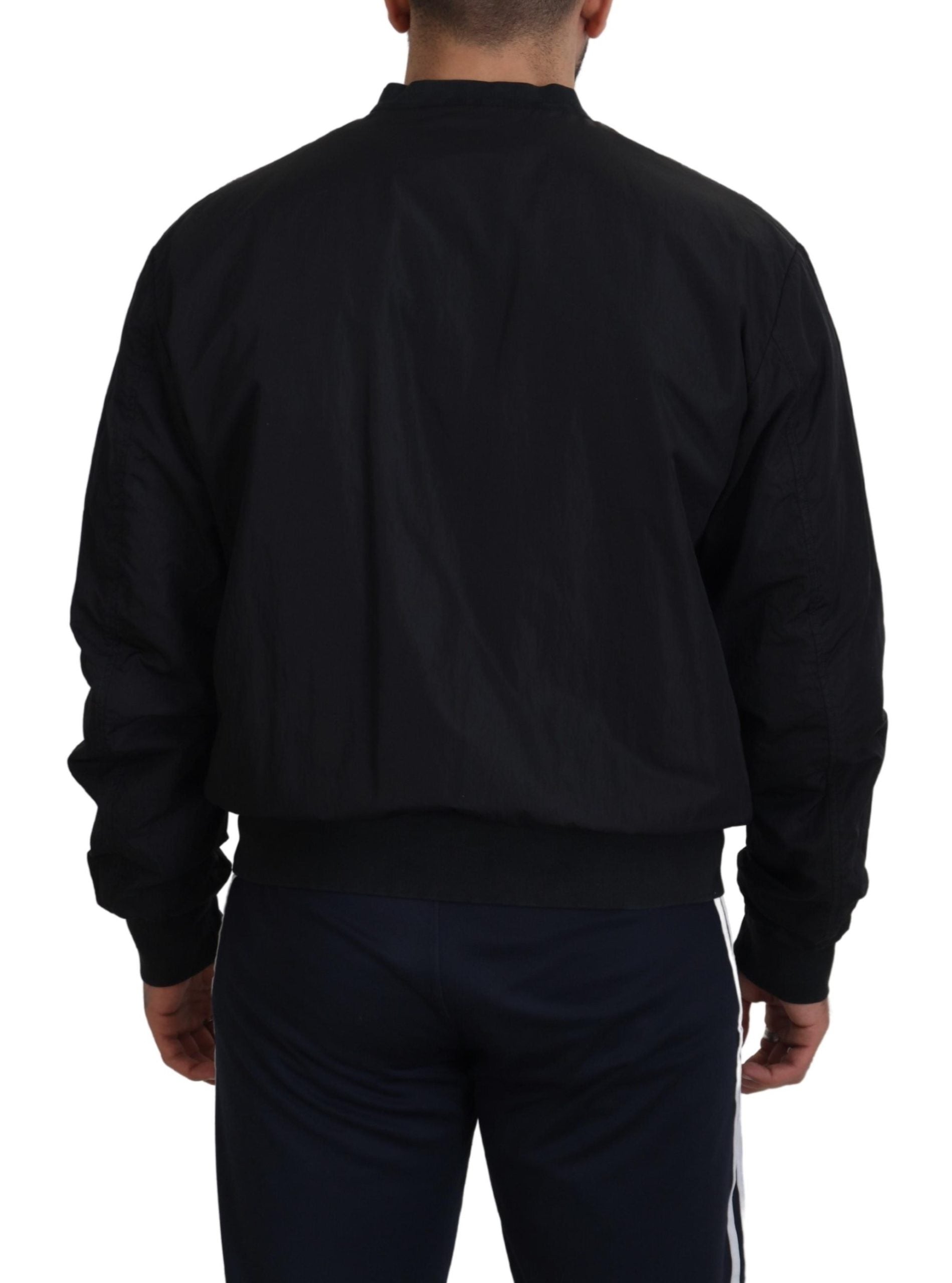 Back view of a man wearing a Dolce & Gabbana black bomber jacket with ribbed cuffs and waistband