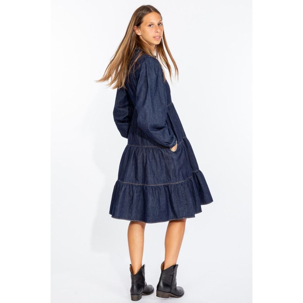 Woman wearing a Love Moschino denim dress with long sleeves and tiered skirt paired with black boots