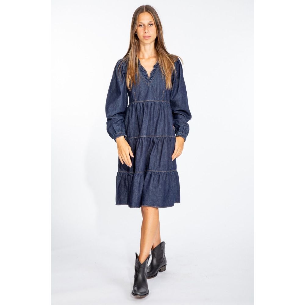 Woman wearing Love Moschino denim dress with long puff sleeves and tiered skirt paired with black ankle boots